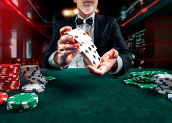 Croupier or casino dealer at gambling club or casino. Close up of male hand. Gambling concept.